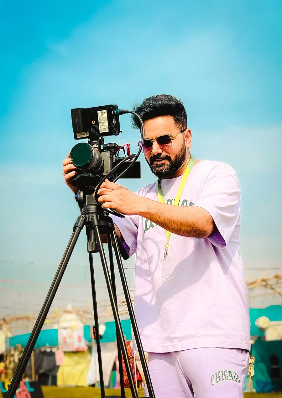Filmmaker operating a professional camera outdoors